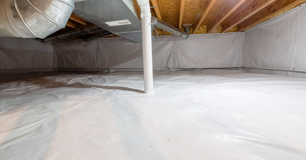 Plastic sheeting lines the floor and walls of an encapsulated basement crawl space. A PVC pipe comes out of the floor.